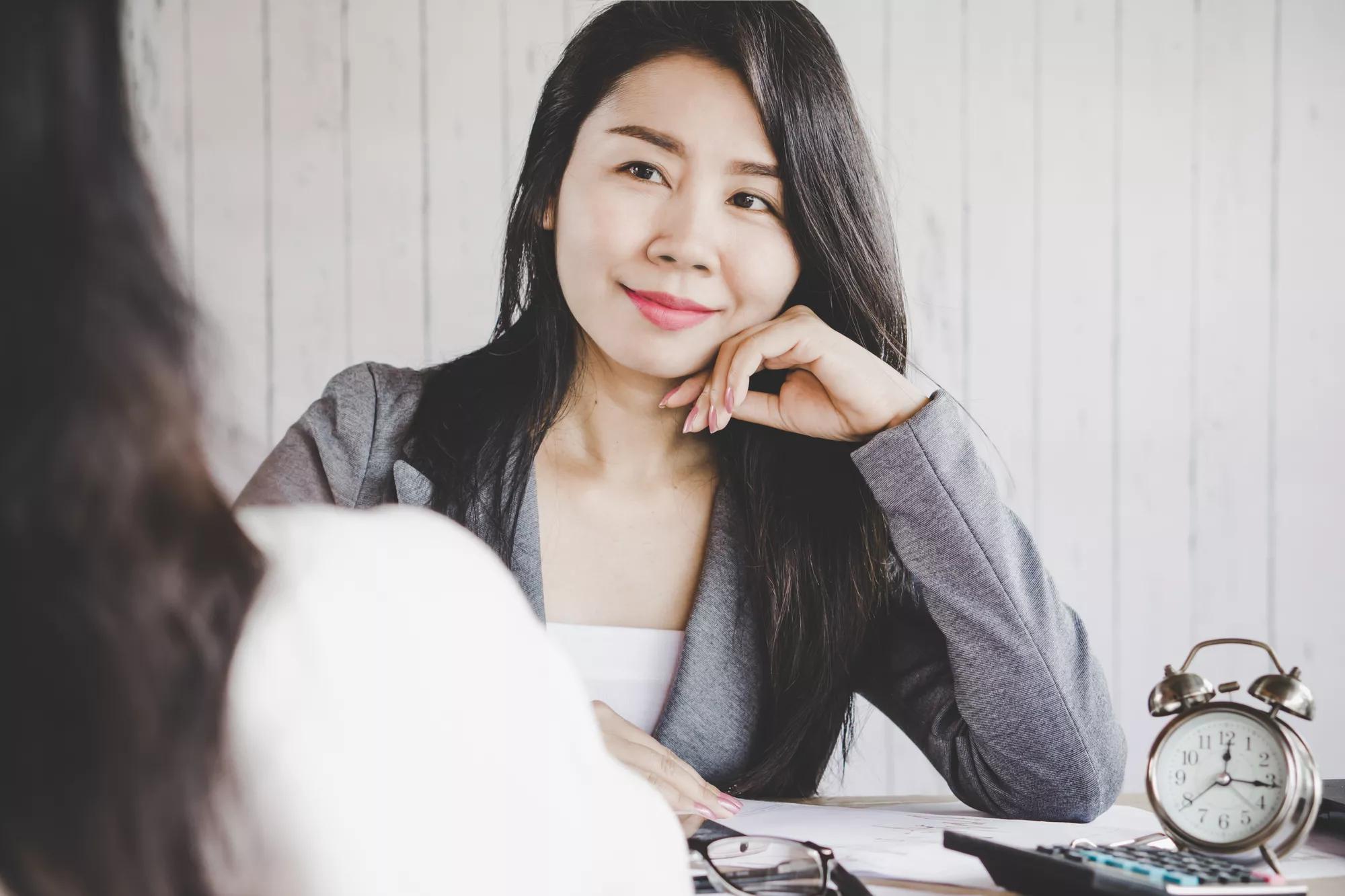 attractive Asian business woman sitting in a meeting room smiling and happy working