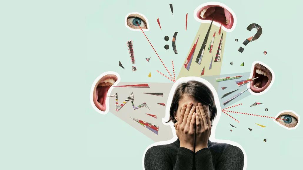 A person covers their face with both hands while magazine cutouts of eyes and yelling mouths direct arrows, paper shards, and zigzags at the person. Other paper cutouts include a question mark, an exclamation mark, a frowny-face emoji, and small triangles.