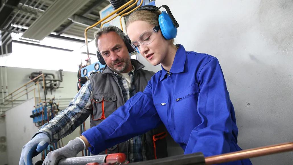 Young woman in professional training to become plumber