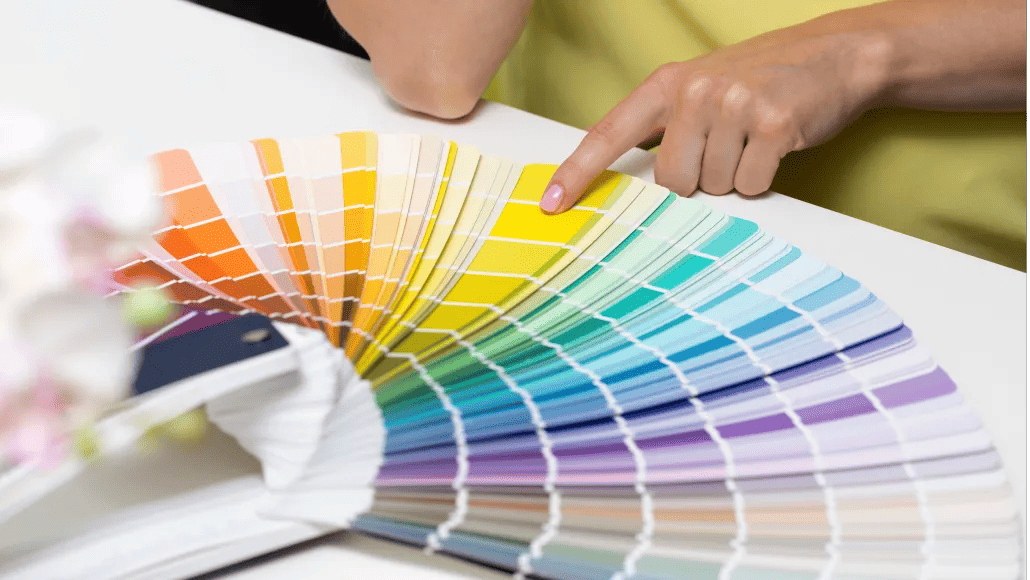 A photo shows someone pointing to a selection from paint color swatches