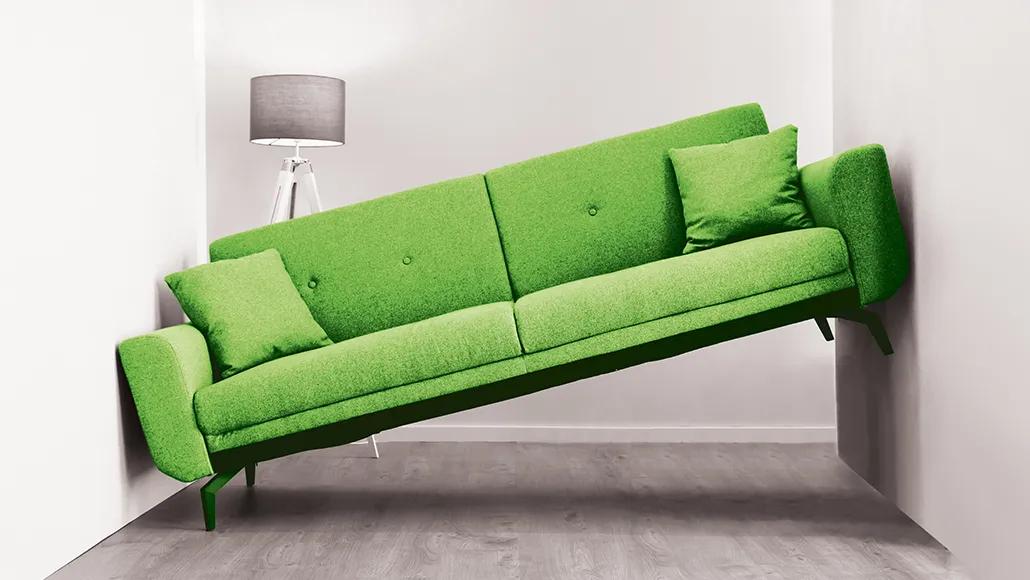 An image of a green couch that is too big for a too-small room