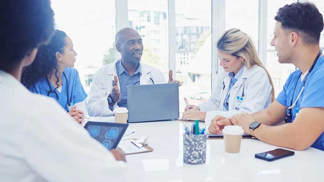 A photo of a healthcare leader meeting with staff