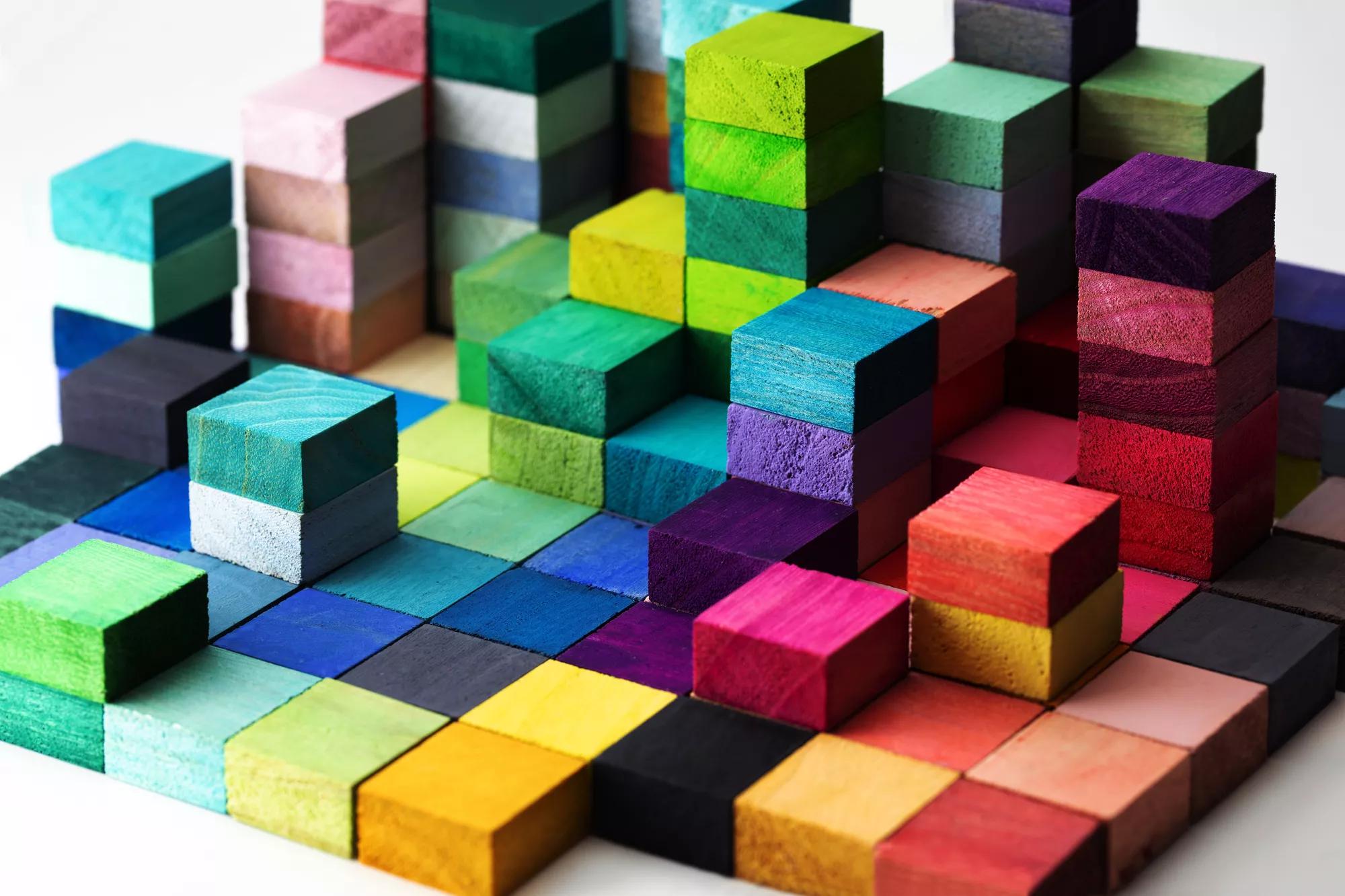 Spectrum of stacked multi-colored wooden blocks. Background or cover for something creative, diverse, expanding,  rising or growing.