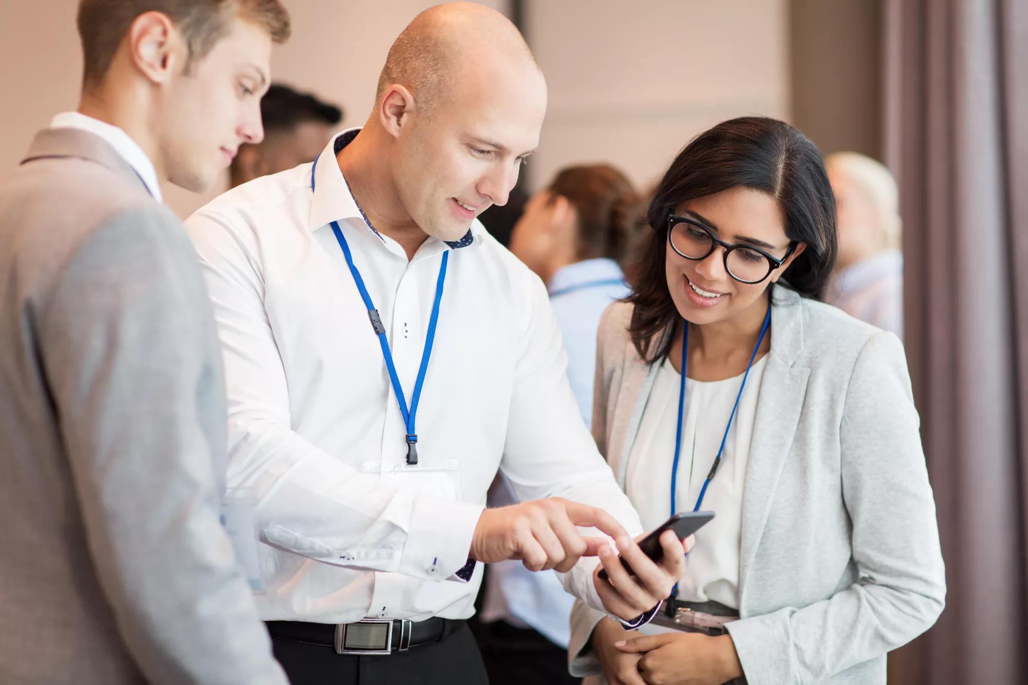 couple with smartphone at business conference