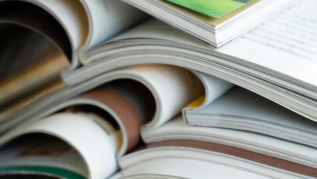 A photograph of a stack of open magazines.