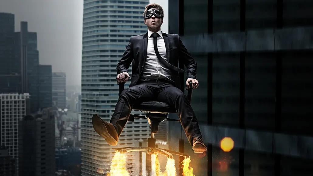 blindfolded man sitting in a chair that has shot up into the air
