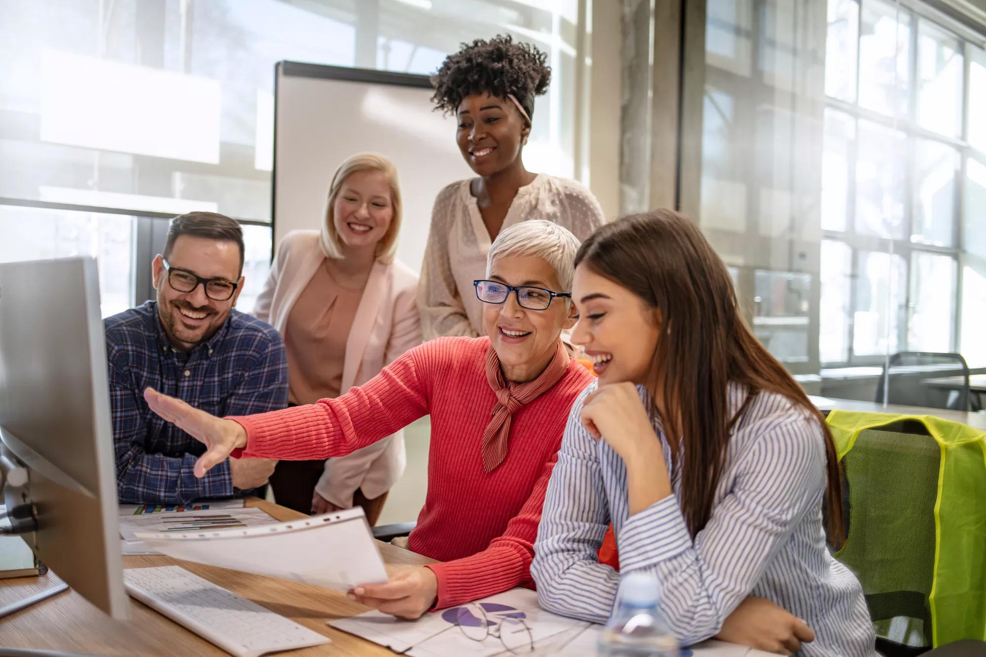 Senior designer giving some new ideas about project to her partners in conference room. Business people discussing over new business project in office. Group of businesspeople or designers work