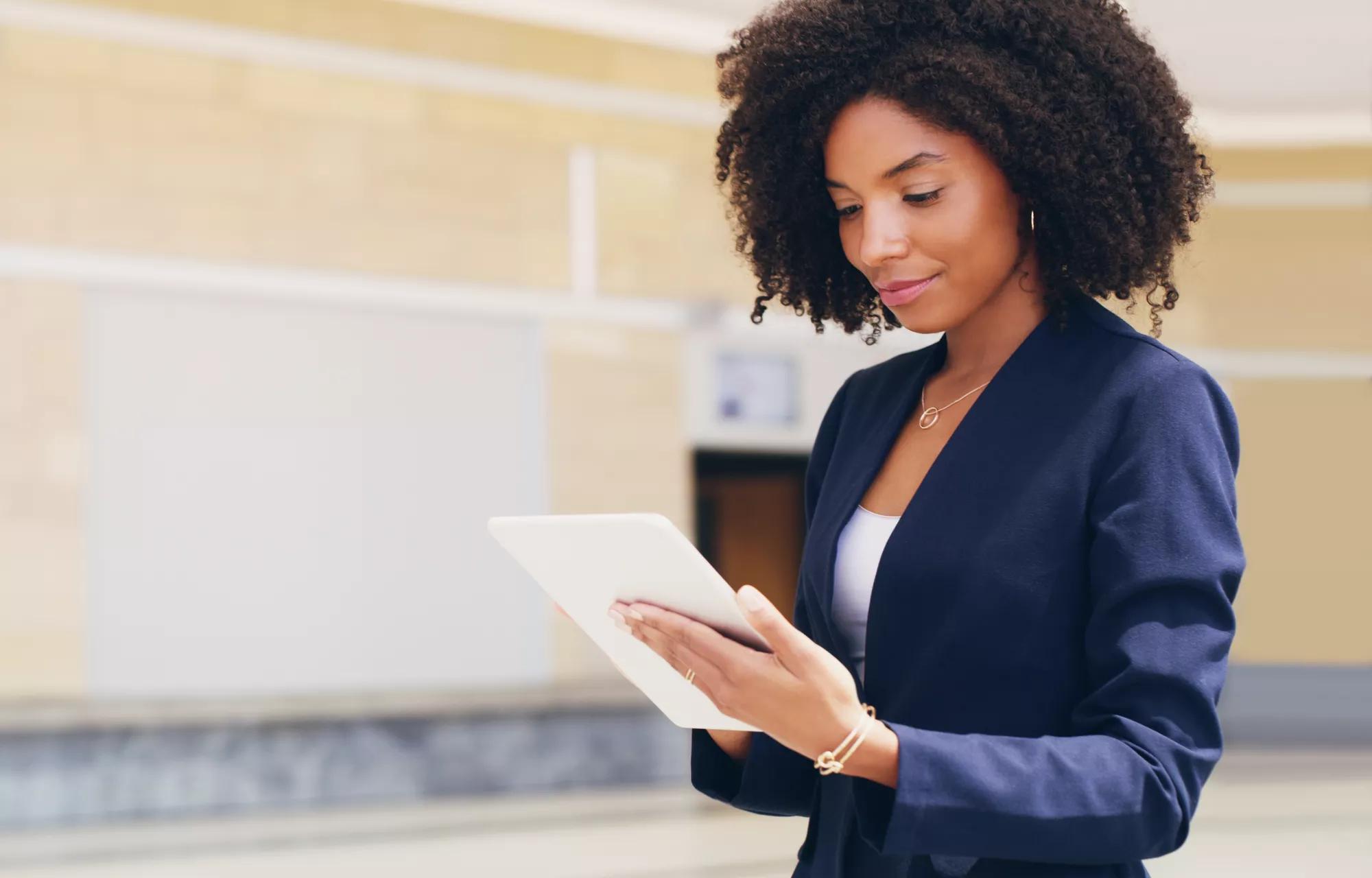 Going through my emails. Cropped shot of an attractive young businesswoman standing alone and using a tablet while in the office during the day.