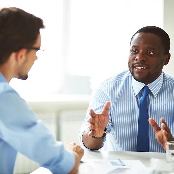 Two young businessmen interacting at a meeting in the office.