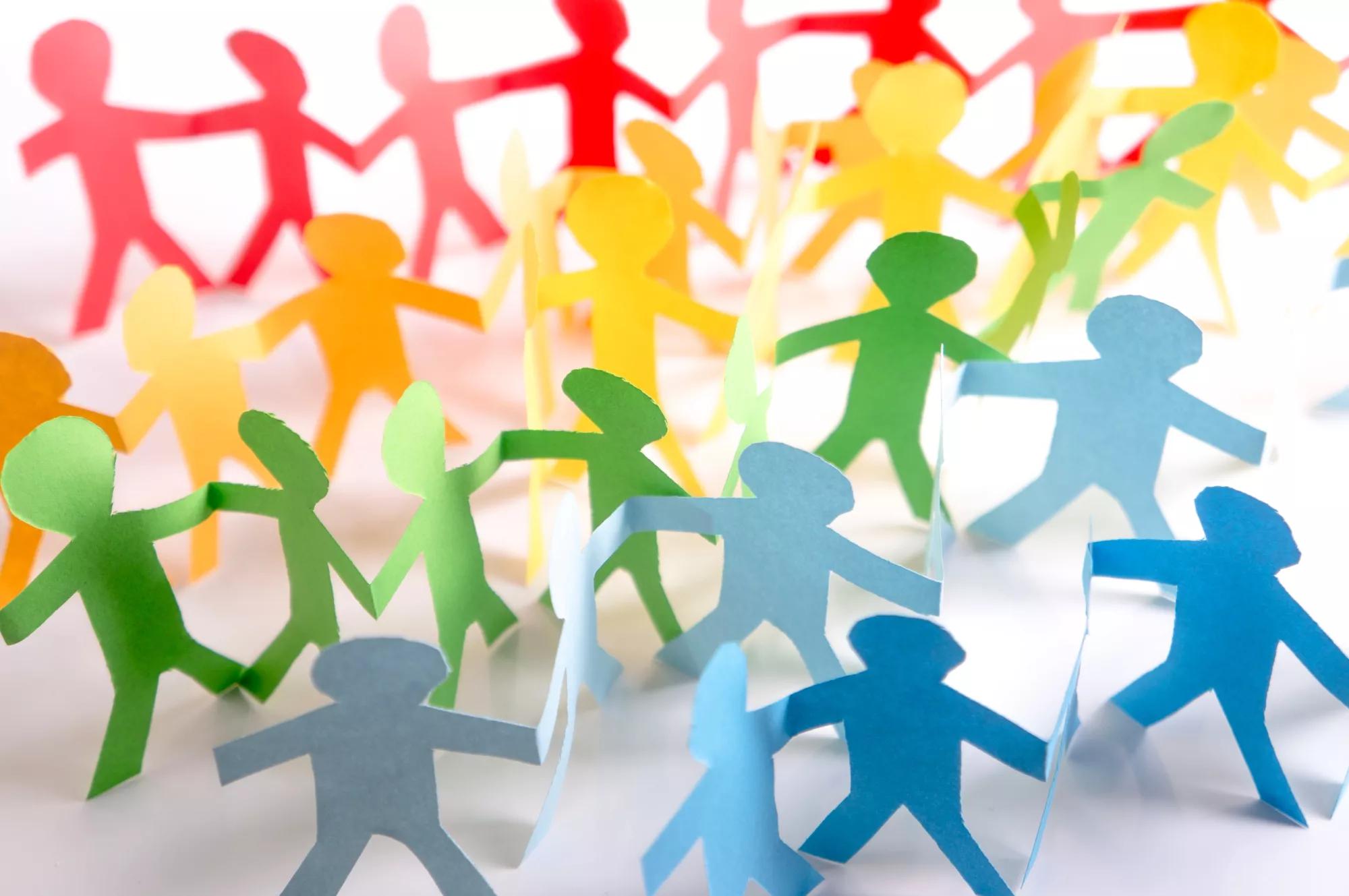 Paper people holding each other in LGBT rainbow colors